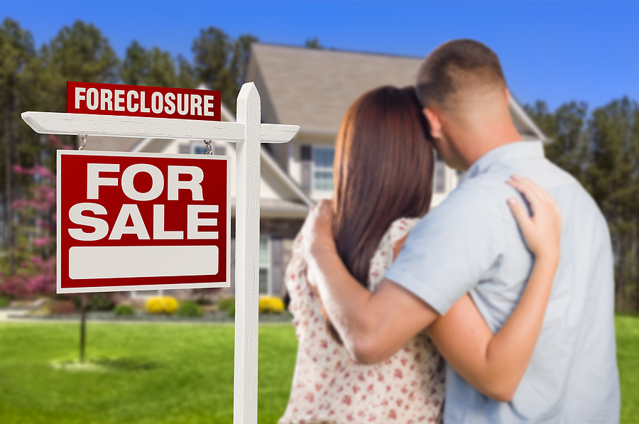 Foreclosure prevention, Military Couple in Front of House and Foreclosure For Sale Real Estate Sign.