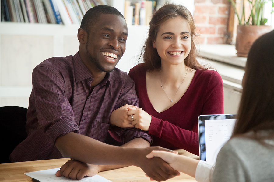 Is it better to hire a lawyer for bankruptcy - Smiling multiracial couple customers shaking hands with bankruptcy lawyer