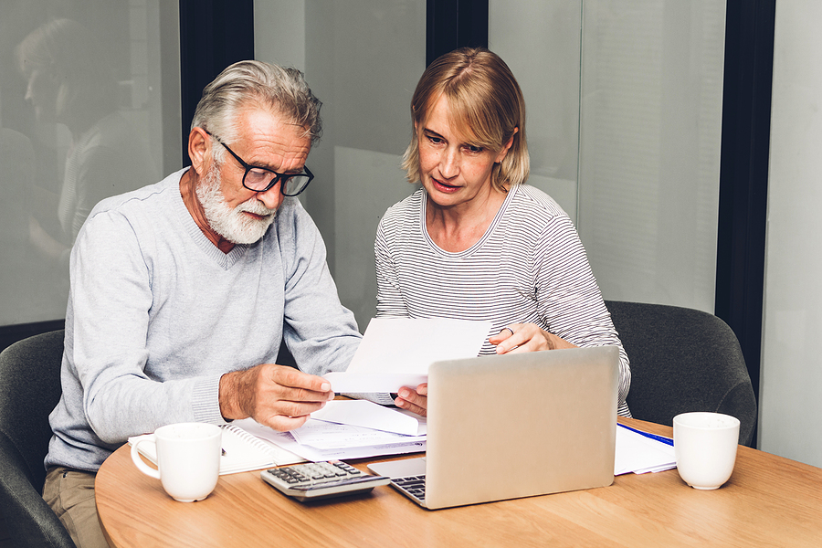 Should you keep bankruptcy papers - Senior couple reading documents and calculating bills to pay in living room at home.Retirement couple and loan bankruptcy money concept